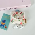 Close-up of quilted floral earphone pouch with white lace trim and plastic hanging hook - Light Pink Flower