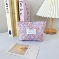 Detail der floralen Jacquard-Kosmetiktasche mit Reißverschluss und Markenetikett - Rosa und Blaues Blumenmuster