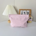 Détail d'une trousse de maquillage en nylon rose avec fermeture éclair et texture froissée - Rose Clair