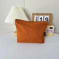 Détail d'une trousse de maquillage en nylon orange avec étiquette et fermeture éclair durable - Orange