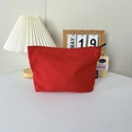 Gros plan sur la trousse cosmétique en nylon rouge avec étiquette bleue décorée - Rouge