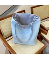 Nahaufnahme der hellblauen Canvas-Tasche mit blau-weißem Karofutter auf einem Stuhl - Blaues Karomuster Doppelseitig