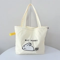 Nahaufnahme der cremefarbenen Canvas-Tasche mit Hasenstickerei und Kordelzug-Detail - Beiger Liegender Hase
