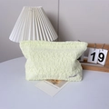 Dettaglio della borsa da trucco color crema con tessuto increspato 3D ed etichetta - Giallo