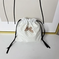 Dettaglio del sacchetto di cotone bianco a pois neri con fiocco a quadretti marrone - Fiocco Cachi a Pois