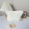 Dettaglio di una trousse bianca con trama a pieghe e piccola etichetta logo MAY RABBIT - Bianco Sporco