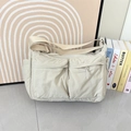 Dettaglio della borsa a tracolla in nylon impermeabile con due tasche frontali e tracolla - Bianco Sporco