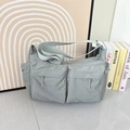 Dettaglio della borsa a tracolla in nylon impermeabile con design multitasche e ampia tracolla - Grigio Nebbia