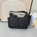 Dettaglio borsa a tracolla in nylon nero impermeabile con due tasche e cinturino regolabile - Nero