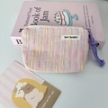 Close-up of pink knitted coin purse with colorful stripes and purple rope zipper pull - Pink