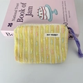 Detail of yellow knit coin purse featuring colorful 3D textures and long purple zipper pull - Yellow