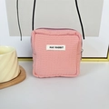 Detailansicht einer rosa Mini-Aufbewahrungstasche mit Waffelstruktur und MAY RABBIT Etikett - Rosa