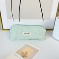 Close-up of mint green pleated fabric pencil case with May Rabbit woven label - Green