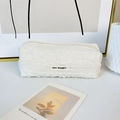 Close-up of cream quilted pleated fabric pencil case with May Rabbit woven label - Off-white