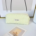 Close-up of pale yellow pleated fabric pencil case with bubble texture and zipper - Yellow