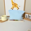 Detail of light blue waffle texture makeup bag with May Rabbit label on books - Blue