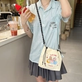 Detail of cream canvas drawstring bucket bag with cute animal embroidery and woven strap - Happy Birthday (Beige)