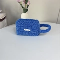 Detail van blauwe pluche handtas met zachte harige textuur en May Rabbit stoffen label - Blauw