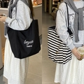 Grande borsa shopper in tela a righe e borsa nera con scritte e tracolle lunghe - merci Righe Nere