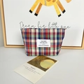 Detailansicht einer karierten Kosmetiktasche mit Spitze und Markenlabel in Deko - Streifen Karo Lippenstift Tasche