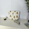 Dettaglio della trama trapuntata e stampa orso sulla borsa da toilette color crema - Astuccio per Rossetto
