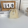 Detailed view of checkered drawstring pouch with woven logo on soft white table - Khaki Plaid