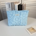 Détail d'une trousse à maquillage matelassée bleu clair avec surpiqûres florales - Coton Matelassé Floral Bleu
