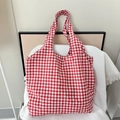 Dettaglio della borsa tote a scacchi rossi e bianchi su un panno bianco a nido d'ape - Scacchi Rossi