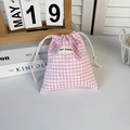 Close-up of pink and white checkered cotton drawstring pouch with woven May Rabbit label - Pink Plaid