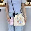 Close-up of beige nylon crossbody bag with cat embroidery and StellaLou phone case - Plaid Cat (Beige)