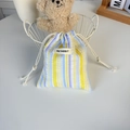 Détail d'un sac à cordon rayé bleu et jaune avec étiquette May Rabbit sur un bureau - Rayé Jaune Violet