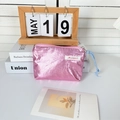 Detail of metallic pink coin purse with wrinkled texture and blue knot zipper pull - Pink