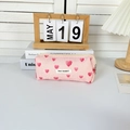 Detailopname van roze hartjes jacquard stof met geborduurd merklabel en ritssluiting - Etui