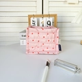 Close-up of pink quilted storage basket with red heart patterns and brand fabric label - Heart Pink