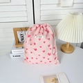 Detailed texture of pink drawstring storage bag with red heart pattern and cotton ropes - Large