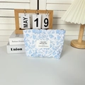 Vue détaillée de la trousse de maquillage matelassée à fleurs bleues et étiquette - Floral Bleu