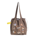 Dettaglio della borsa tote marrone con coulisse, ricami di dolci e cinturino giallo - Pane (Marrone)