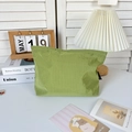 Dettaglio della borsa da trucco in nylon a scacchi verdi su scrivania in stile ins - Verde