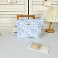 Quilted floral makeup bag in white and blue patterns with a woven logo tag - Blue Floral