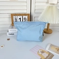 Dettaglio borsa da toilette in nylon ripstop azzurro con trama a quadretti e zip circolare - Blu