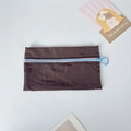 Detail of checkered nylon pouch with contrast blue zipper and pink edge trim - Brown