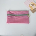 Close-up of pink checkered nylon pouch with contrasting blue zipper and round ring puller - Pink