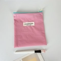 Detalle de mini neceser rosa de cuadros con cremallera en contraste y etiqueta tejida - Rosa