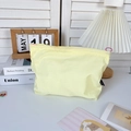 Dettaglio di una borsa da toilette in nylon a scacchi giallo pallido con cerniera rosa - Giallo