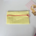 Detail of yellow checkered nylon pouch featuring a contrast pink zipper with large ring puller - Yellow