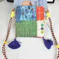 Dettaglio ravvicinato di una borsa a tracolla etnica vintage con patchwork e nappe viola - Mini Borsa a Tracolla Patchwork a Blocchi di Colore