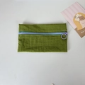 Detail of green checkered nylon pouch with contrasting purple ring zipper pull - Green