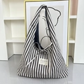 Close-up of black and white striped canvas tote bag with adjustable bow and textile label - Black Striped Double-Sided Vest Bag