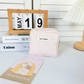 Detail van de roze geruite mini cosmetische tas met rits en May Rabbit-label op een tafel - Lichtroze Geruit