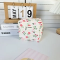Détails d'une trousse de maquillage matelassée fleurie avec fermeture éclair et logo - Fleur Rose Clair
